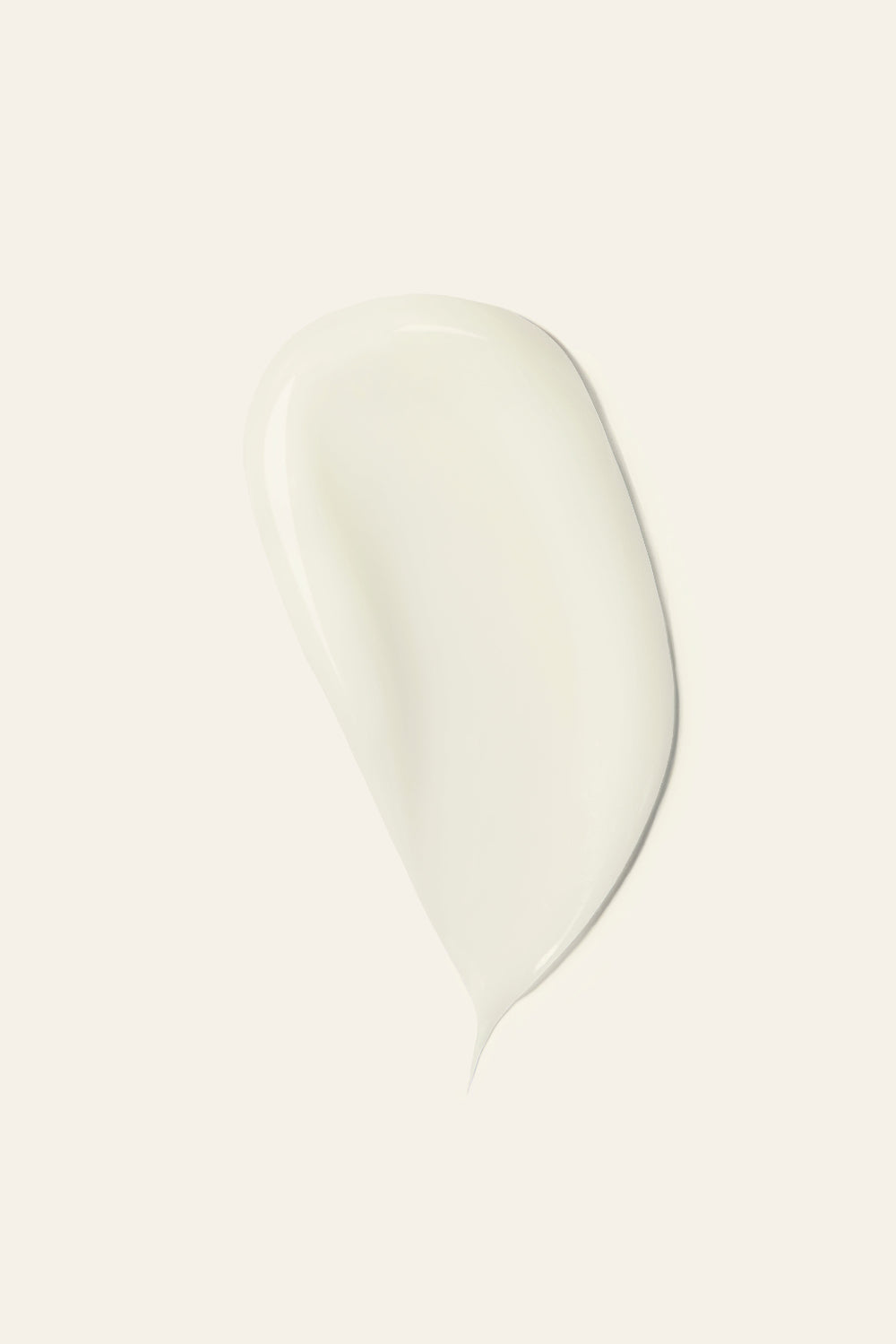 A smooth, glossy swatch of creamy off-white cosmetic product, likely a cream or lotion, on a solid off-white background.