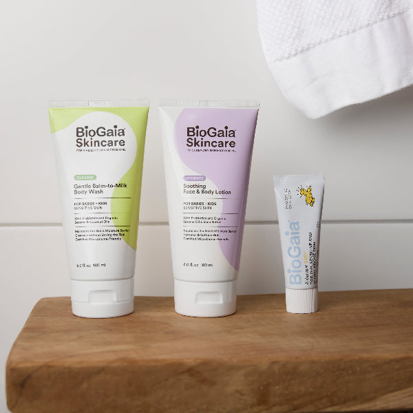 Three BioGaia Skincare products on a wooden surface with a white towel in the background.