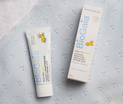 BioGaia Skincare Aldermis Probiotic Ointment tube on a blue textured blanket background.