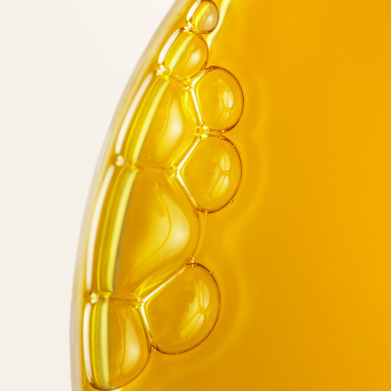 Close-up of yellow oil with bubbles on a gradient background